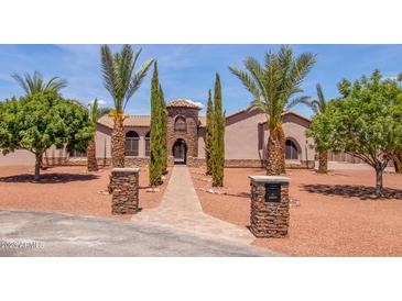 Stunning desert home with palm trees and a paved pathway at 18654 W Solano Dr, Litchfield Park, AZ 85340