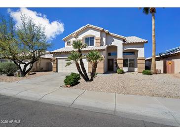 Charming two-story home featuring desert landscaping, a two-car garage, and a beige stucco exterior at 19406 N 31St Way, Phoenix, AZ 85050
