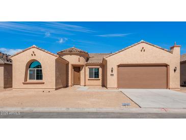 Charming single-story stucco home featuring a tile roof, attached garage, and desert landscaping at 7682 W Mockingbird Way, Florence, AZ 85132
