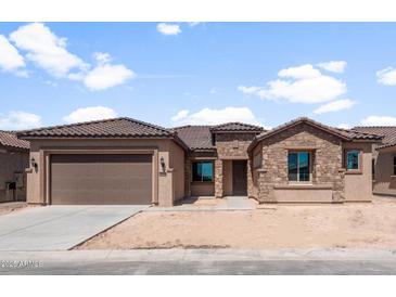 Charming single-story home with a stone facade, tile roof, and a spacious two-car garage at 7736 W Mockingbird Way, Florence, AZ 85132