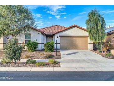 One-story home with tan exterior, two-car garage, and landscaping at 26722 N 174Th Ln, Surprise, AZ 85387