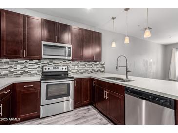 Modern kitchen features dark wood cabinets, stainless steel appliances, and mosaic backsplash at 2821 S Skyline Dr # 123, Mesa, AZ 85212