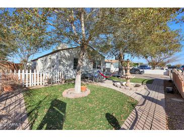 Charming home with a spacious front yard, featuring a fountain and a hammock at 3206 W Garfield St, Phoenix, AZ 85009