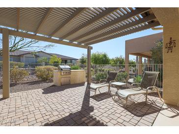 Relaxing patio with built-in grill and pergola at 17547 W Silver Fox Way, Goodyear, AZ 85338