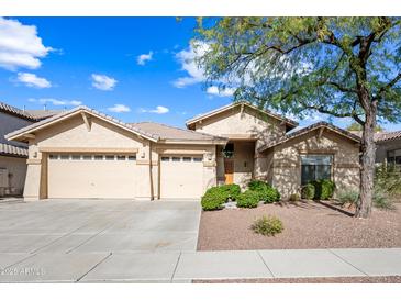 Tan two-story house with two-car garage, landscaping, and a walkway at 2122 W Red Range Way, Phoenix, AZ 85085