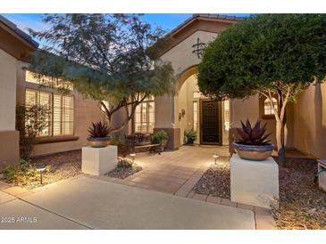 Elegant home exterior with landscaped courtyard, inviting entryway, and charming architectural details at 41348 N Congressional Dr, Anthem, AZ 85086