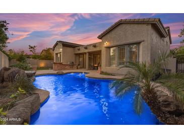Inviting pool with waterfall feature at twilight at 501 E Sunburst Ln, Tempe, AZ 85284