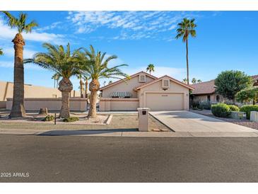 Charming single-story home featuring desert landscaping, palm trees, and a two-car garage at 10309 E Twilight Ct, Sun Lakes, AZ 85248