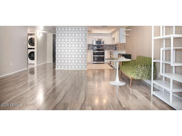 Spacious living room showing the kitchen, featuring wood floors and an open floorplan at 7970 E Camelback Rd # 101, Scottsdale, AZ 85251