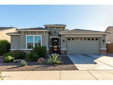 Single-story home with a two-car garage and desert landscaping at 18865 W Mescal St, Surprise, AZ 85388