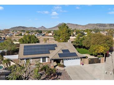 Aerial view showing house with solar panels, large backyard, and mountain views at 24444 N 40Th Ln, Glendale, AZ 85310