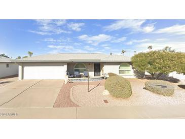 Ranch-style home with landscaped yard, driveway, and two-car garage at 7960 E Madero Ave, Mesa, AZ 85209