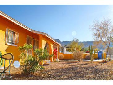 Bright yellow house with a landscaped front yard, mountain views, and a spacious driveway at 8213 S 25Th St, Phoenix, AZ 85042