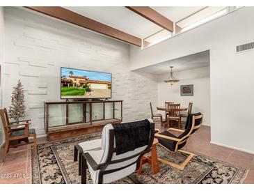 Spacious living area with wood beams, tiled floors and a large TV at 9734 N 105Th Dr, Sun City, AZ 85351