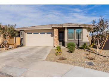 Single-story home with a two-car garage and desert landscaping at 19122 W Solano Dr, Litchfield Park, AZ 85340