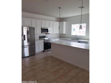 Modern kitchen with stainless steel appliances and an island at 20 W Whyman Ave, Avondale, AZ 85323