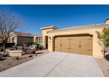 Front view of single-story home with tan colored exterior, two-car garage, and landscaped yard at 392 E Laddoos Ave, Queen Creek, AZ 85140