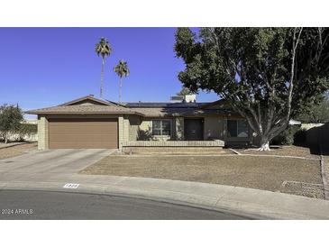 Single story home with brown brick exterior, two-car garage, and mature landscaping at 1320 W Palo Verde Dr, Chandler, AZ 85224