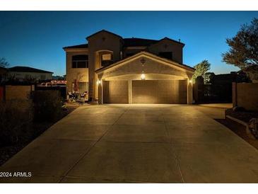 Two-story house with a three-car garage, illuminated at night at 4913 W Pedro Ln, Laveen, AZ 85339