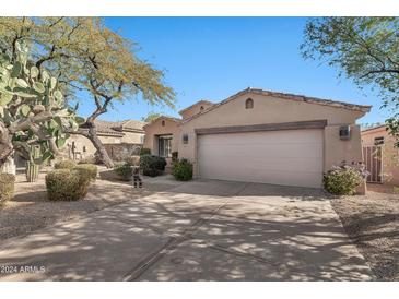 Desert landscape surrounds this single-story home with a two-car garage at 8179 E Sierra Pinta Dr, Scottsdale, AZ 85255