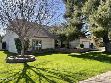 One-story house with a well-maintained lawn and mature trees at 133 W Las Palmaritas Dr, Phoenix, AZ 85021