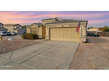 House exterior featuring a two-car garage and well-manicured front yard at 1722 E San Xavier Dr, Casa Grande, AZ 85122