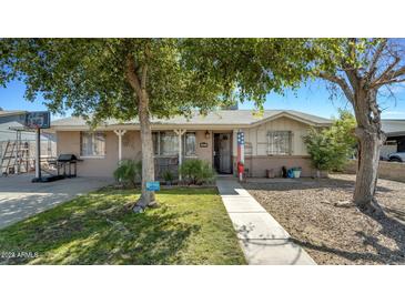 Ranch style home with mature trees and a well-maintained lawn at 5625 N 67Th Dr, Glendale, AZ 85303