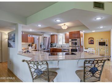 Updated kitchen with granite island and stainless steel appliances at 10113 W Kingswood Cir, Sun City, AZ 85351