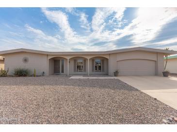 Tan one-story home with a two-car garage and desert landscaping at 10845 W Kaibab Dr, Sun City, AZ 85373