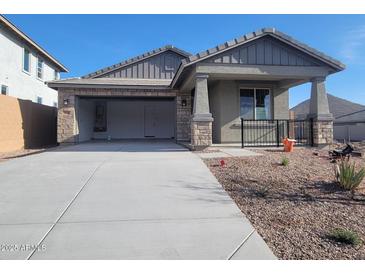 New single-story home with stone and gray siding, attached garage, and a landscaped front yard at 33333 N 132Nd Dr, Peoria, AZ 85383