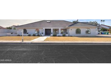 White single story home with a grassy lawn and mature trees at 4053 E Glencove St, Mesa, AZ 85205