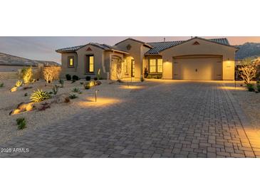 Beautiful desert landscape with single-story home, two-car garage, and lighted driveway at 13271 E Desert Vista Rd, Scottsdale, AZ 85255