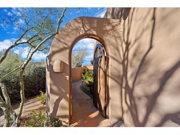 Spanish-style entry with arched gate and paved pathway leading to the home at 6930 E Stevens Rd, Cave Creek, AZ 85331