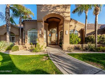 Elegant home exterior with arched entryway and landscaping at 9053 N 46Th St, Phoenix, AZ 85028
