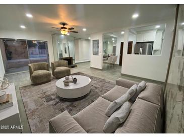 Open living room with modern decor, plush seating, and view to the backyard pool area at 102 W Maryland Ave # F1, Phoenix, AZ 85013
