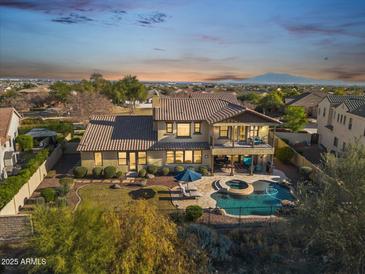 Expansive backyard with a pool, spa, lush landscaping, and a covered patio overlooking the scenic neighborhood at 3428 N Park St, Buckeye, AZ 85396