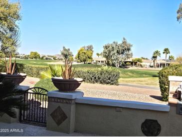 Backyard view of a golf course with lush greenery and houses in the background at 13414 W Micheltorena Dr, Sun City West, AZ 85375