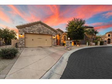 Beautiful stone house with a three-car garage and nicely landscaped front yard at 11714 N 134Th St, Scottsdale, AZ 85259