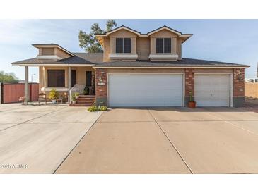 Two-story house with a brick facade, three-car garage, and landscaped front yard at 8934 W Ocotillo Rd, Glendale, AZ 85305
