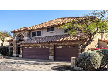 Two-story home with stone accents and three-car garage at 11343 N 129Th Way, Scottsdale, AZ 85259