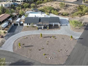 Stunning aerial view of a modern home with a pool, desert landscaping, and a circular driveway at 12524 E Saddlehorn Trl, Scottsdale, AZ 85259