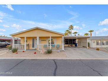 Front view of a yellow single-story home with covered porch and carport at 2400 E Baseline Ave # 189, Apache Junction, AZ 85119