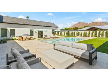Stunning backyard showcasing a pristine pool, lush lawn, and comfortable outdoor seating areas at 6040 E Lafayette Blvd, Scottsdale, AZ 85251