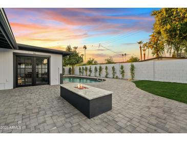 Sunset view of backyard with pool and fire pit at 1302 W Golden Ln, Phoenix, AZ 85021