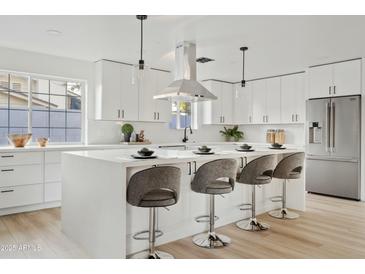 Modern white kitchen with island, stainless steel appliances, and breakfast bar at 1302 W Golden Ln, Phoenix, AZ 85021