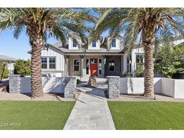 Stunning home exterior with an orange door, manicured lawn, and regal palm trees on a clear, sunny day at 19702 E Melissa Pl, Queen Creek, AZ 85142