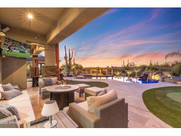 Relaxing backyard patio with firepit and comfortable seating, overlooking a stunning pool and desert landscape at 27432 N 66Th Way, Scottsdale, AZ 85266