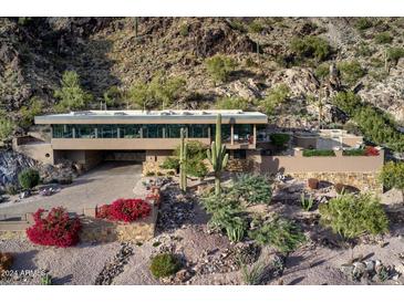 Stunning aerial view of modern home nestled into mountainside with pool and expansive views at 5800 E Glen Dr, Paradise Valley, AZ 85253