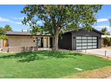 Modern mid-century home with a dark gray garage and spacious lawn at 6733 N 14Th St, Phoenix, AZ 85014