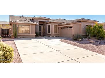 Single-story home with a large driveway and desert landscaping at 8141 E Apache Plumb Dr, Gold Canyon, AZ 85118
